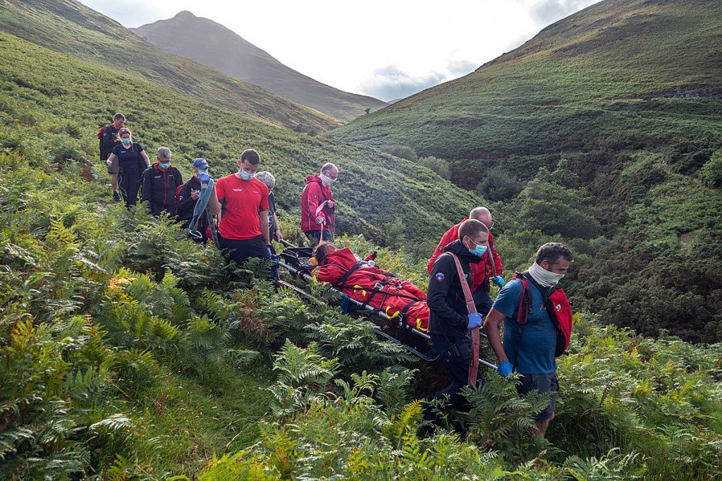 Team members stretcher the injured woman from the fellside. Photo: Keswick MRT