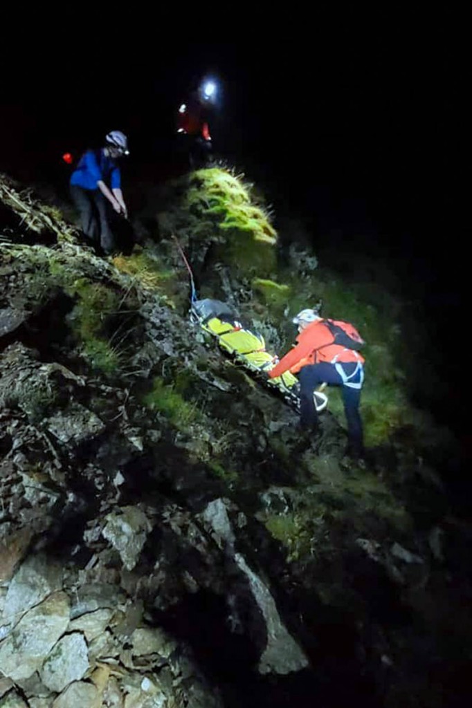 Rescuers lower the stretcher down the headwall. Photo: Patterdale MRT