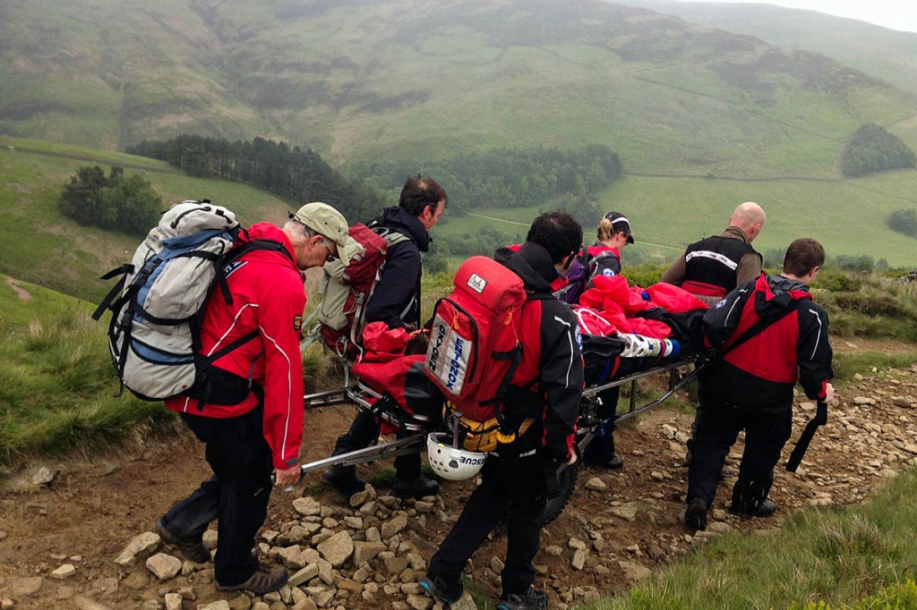 Rescuers stretcher the runner from the hill. Photo: Edale MRT